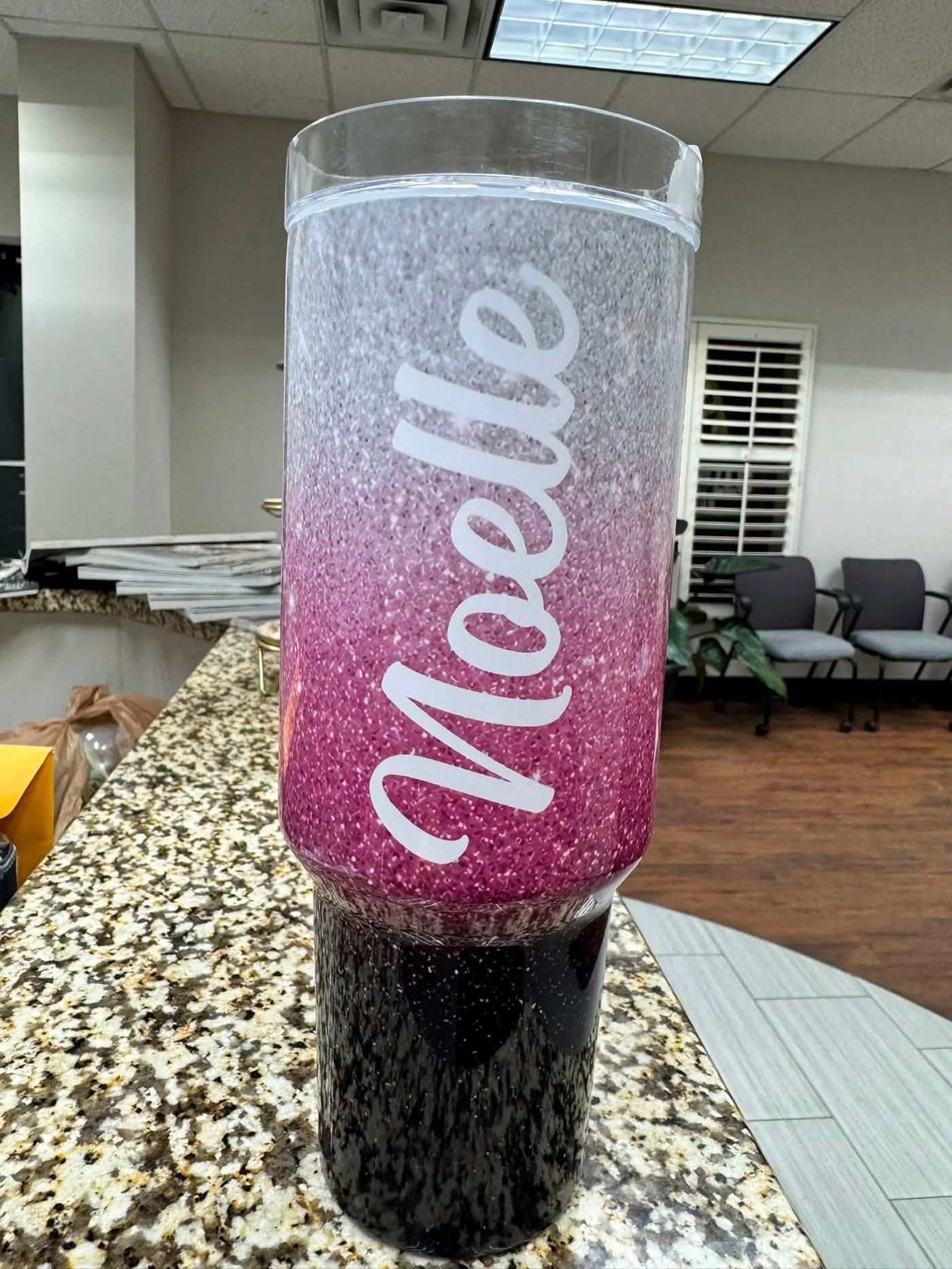 Pink and black glitter tumbler personalized with the name Noelle